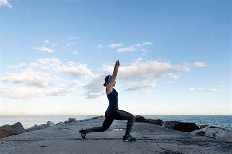 Persona practicando yoga frente al mar